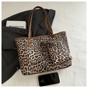 Detailed close-up of leopard print tote bag set with matching small pouch and brown handles