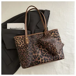 Detail of leopard print tote bag set featuring brown handles and matching pouch