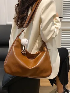 Brown faux leather hobo shoulder bag with a cute plush charm and wide strap for women