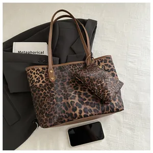 Detail view of large leopard print tote bag set with matching pouch on white fabric