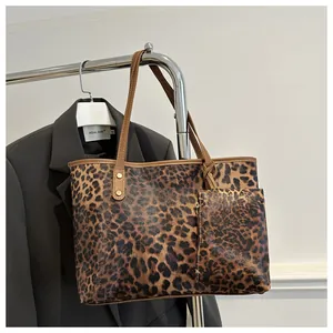 Close-up of leopard print tote bag set with golden rivets and textured brown straps