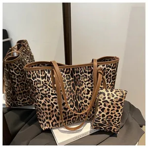 Detail of leopard print tote bag with brown faux leather handles and matching pouch