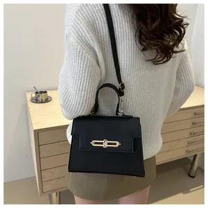 Détail d'un sac noir en cuir PU grainé avec fermoir doré en métal et vue de profil