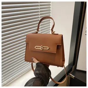 Détail du cuir PU grainé et du fermoir doré sur un sac à main marron caramel