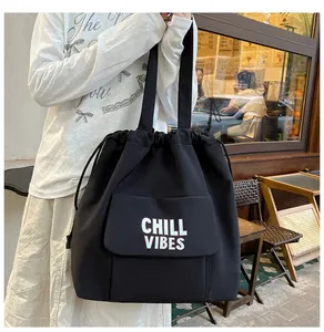 Detail van zwarte nylon draagtas met Chill Vibes-letterprint en voorvak met klepsluiting
