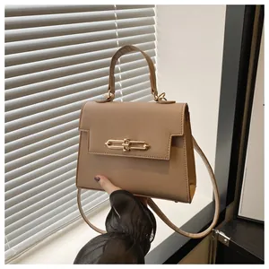 Détail de la texture en cuir PU litchi et boucle dorée sur le sac Kelly de couleur kaki