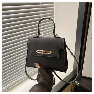 Détail du sac noir en cuir PU grainé avec un fermoir en métal doré élégant et chic