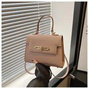 Détail du sac Kelly beige rose avec boucle dorée et poignée en cuir texturé