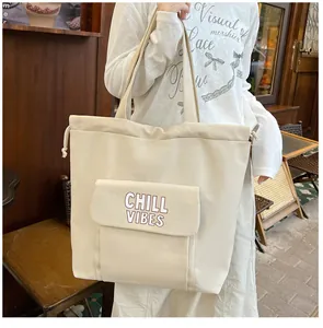 Detail van beige tote bag met Chill Vibes print, trekkoord en voorvakje voor vrouwen