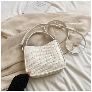 Détail de la texture tissée du sac à main crème avec poignée et bandoulière réglable