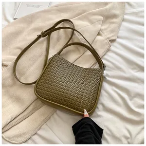Détail de la texture en cuir PU tressé vert olive et ferrures argentées sur ce sac à main