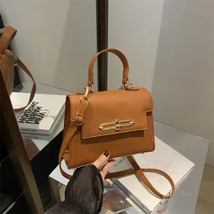 Sac à main élégant en cuir marron caramel avec motif litchi, fermoir doré et bandoulière