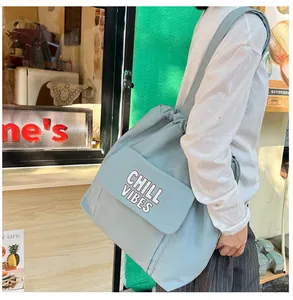 Detail van mintblauwe tote bag met CHILL VIBES-belettering en trekkoordsluiting