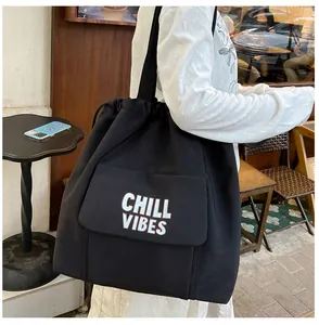 Detail van de zwarte nylon draagtas met Chill Vibes-print en handige klepzak voorop