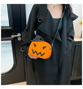 Close-up of Halloween pumpkin crossbody bag with black face detail on black coat outfit