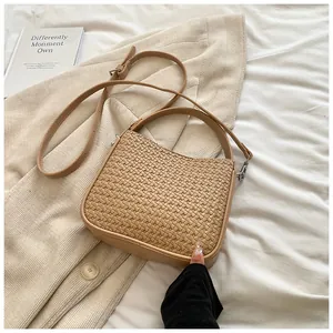 Détail macro de la texture en cuir tressé beige d'un sac à main minimaliste élégant
