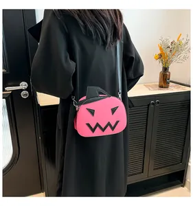Pink pumpkin crossbody bag with black witch hat lid shown worn by a female model
