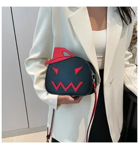 Detail of Halloween pumpkin shoulder bag on model with red accents and detachable strap