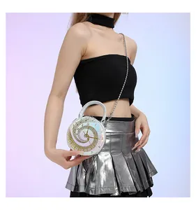 Détail du sac rond argenté en forme d'horloge avec bandoulière chaîne et cadran doré