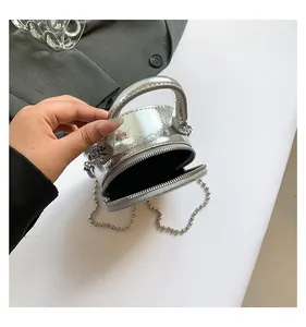 Détails de ce mini sac rond argenté brillant avec texture métallique à effet miroir poli