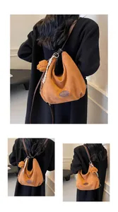 Détail du sac bandoulière en suédine marron avec corde tressée et charme ours en peluche