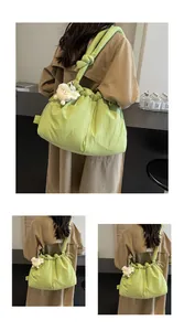 Detalle de bolso bandolera fruncido verde brillante con cordón y colgante de oveja suave