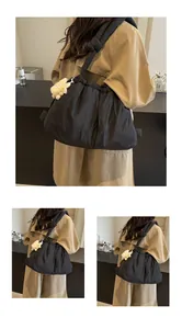 Detalle de bolso tote acolchado negro con cordón y amuleto de conejo de peluche blanco
