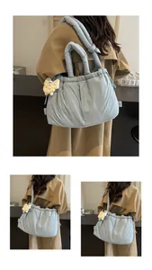 Detalle de bolso nube acolchado azul claro con lindo colgante de peluche beige