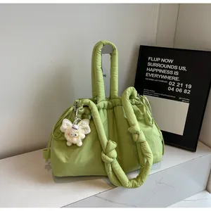 Detalle del bolso bandolera acolchado verde claro con cordón y un colgante de oveja de felpa