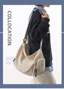 Détail de la bandoulière réglable et de la poche zippée latérale sur un sac besace en nylon beige