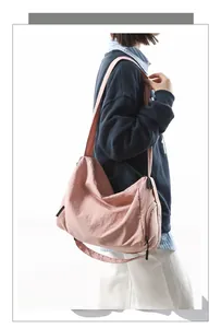 Vue latérale détaillée du grand sac bandoulière en nylon rose avec poche zippée