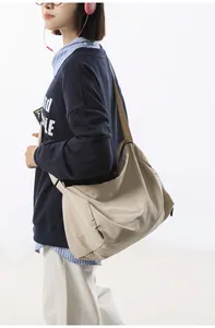 Détail d'un grand sac bandoulière en nylon kaki montrant la texture et la sangle réglable
