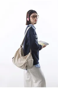 Gros plan sur la poche latérale zippée d'un grand sac bandoulière en nylon beige