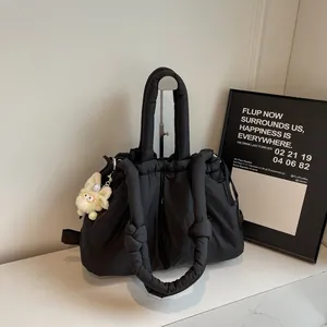 Bolso acolchado negro con cierre de cordón y un bonito colgante de conejo de peluche