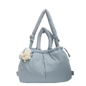 Bolso acolchado azul claro con cordón ajustable y colgante de peluche blanco suave
