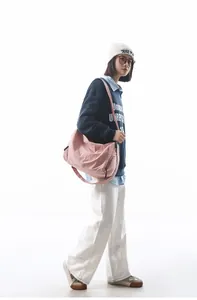 Photo de style de vie d'un grand sac bandoulière rose en nylon porté en mode décontracté