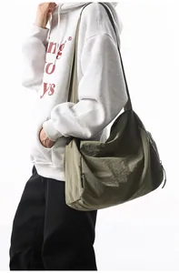 Vue détaillée d'un sac messager en nylon vert olive avec bandoulière réglable et logo