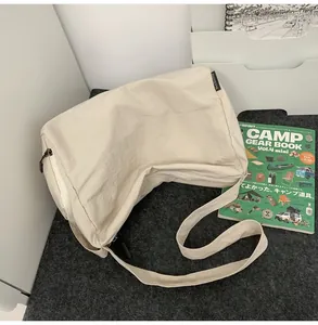 Détail d'un sac bandoulière en nylon beige avec étiquette de marque sur le côté