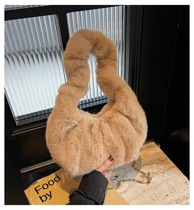 Gros plan du sac en peluche camel avec une élégante bandoulière en chaîne dorée