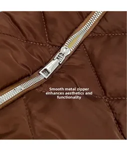 Macro detail of polished silver zipper pull on brown quilted rhombic shoulder bag