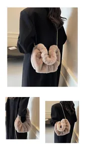 Détail de texture d'un sac bandoulière en fausse fourrure beige avec chaîne dorée