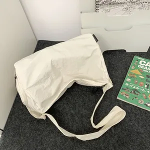 Sac bandoulière minimaliste en nylon blanc crème avec large sangle en cadre épuré