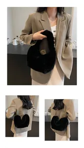 Détail du sac à main en fourrure noire en forme de cœur avec chaîne dorée sur mannequin