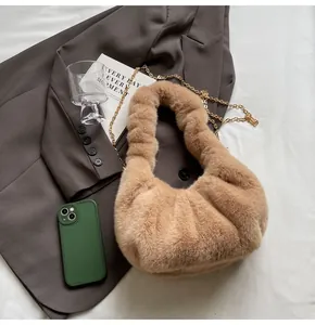 Détail du sac à bandoulière en fausse fourrure douce avec chaîne dorée sur blazer