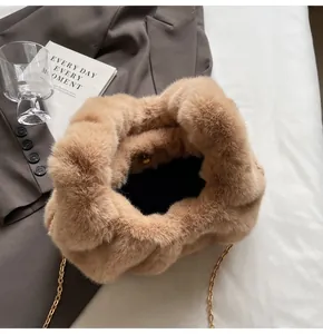 Détail du sac en fausse fourrure camel avec chaîne dorée et fermoir magnétique sur blazer