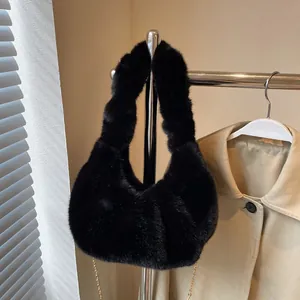 Sac à main chic en peluche noire avec chaîne dorée élégante sur un support de design