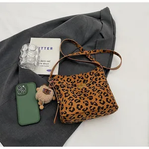 Dettaglio borsa leopardata con chiusura a rotazione dorata e ciondolo a forma di leone