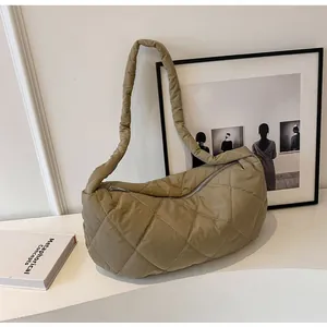 Detailed macro view of quilted puffer shoulder bag with stylish khaki diamond texture