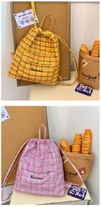 Dettaglio degli zaini trapuntati con coulisse e motivi a scacchi gialli e rosa