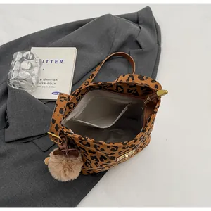 Dettaglio interno della borsa leopardata con tasca a zip e ciondolo di peluche